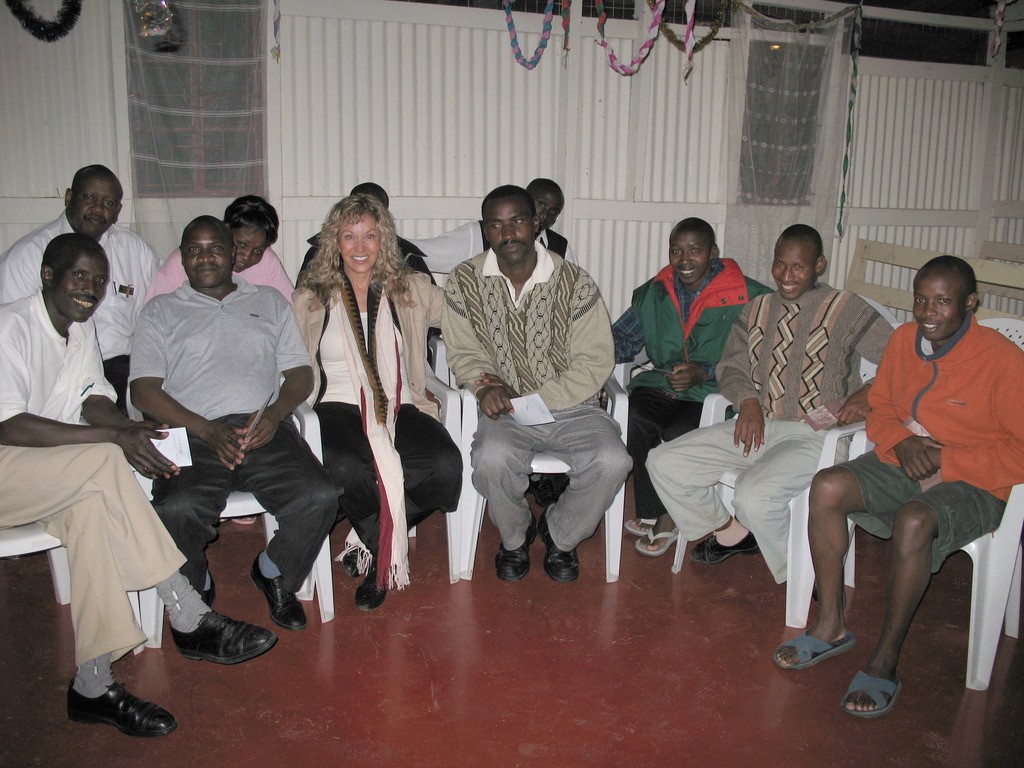 Marlise Karlin smiling and sitting with diverse group of men